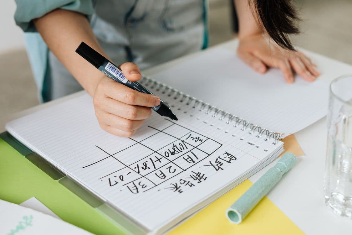 Woman writing a declutter plan in a notebook