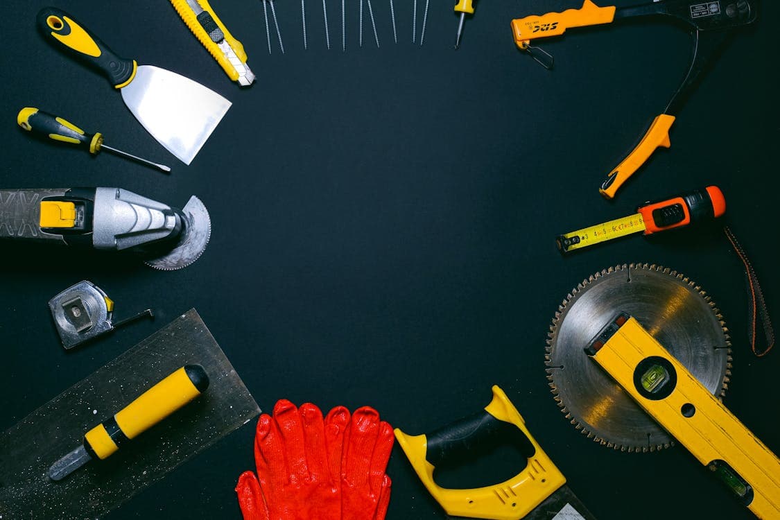 Professional handyman tools laid out — drills, saws, levels and gloves ready for home repairs