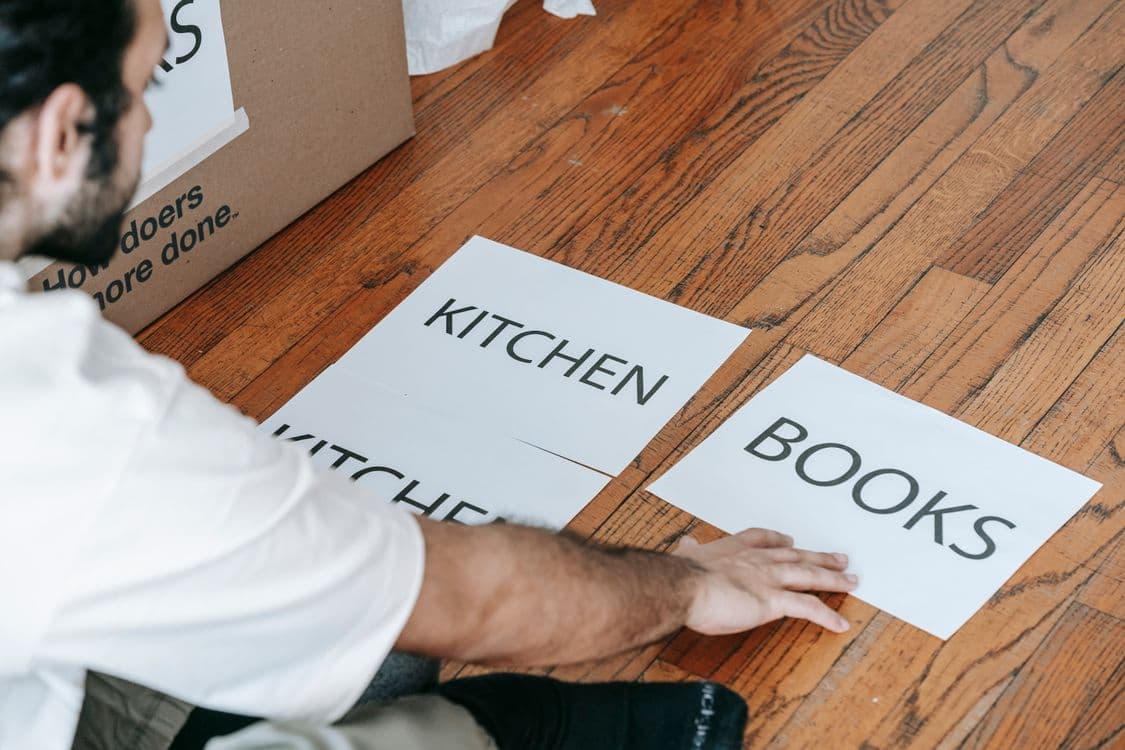 Man sorting and labelling household items before removal