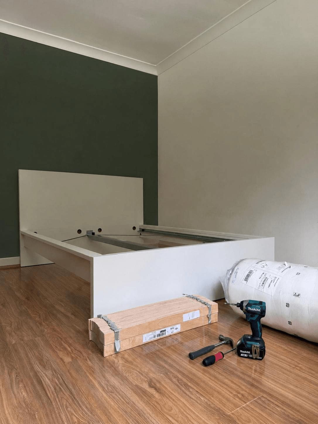 Assembled timber-look bed frame with every sprung slat seated in its holder, photographed before the mattress went on