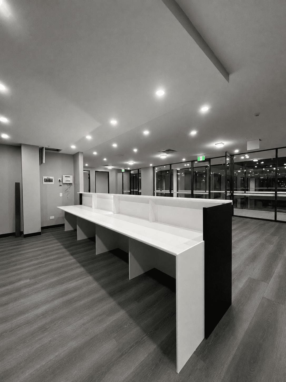Custom-built white reception desk run with a black end panel, assembled and aligned by Liztty during an office fit-out