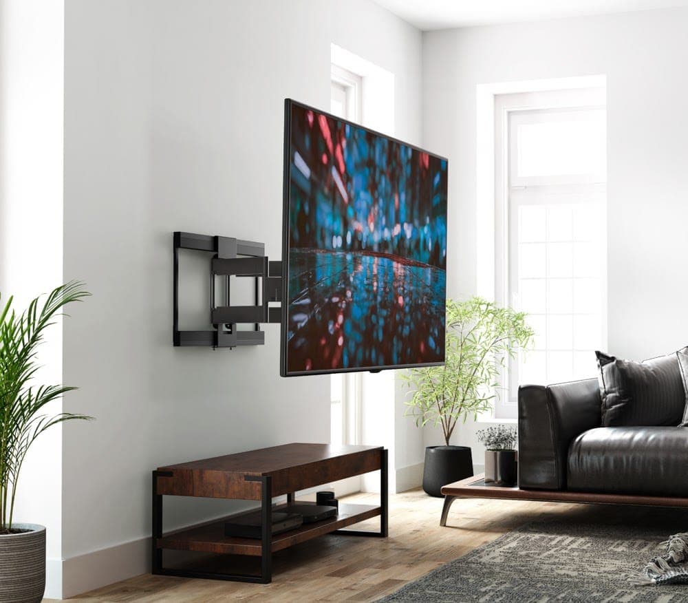 A TV on a full-motion bracket swung out from a white living room wall, its articulated arm extended above a timber console